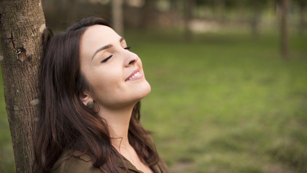 Mujer sonriendo con paz interior. Sentimientos