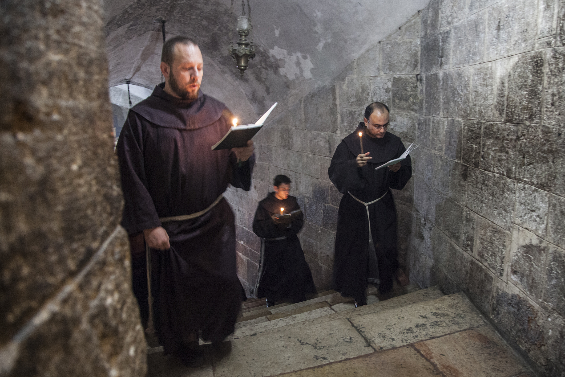 Jerusalem, Israel – November 26, 2013: Franciscan monks in the Church of Holy Sepulchre during their daily precession. – shutterstock_571093945