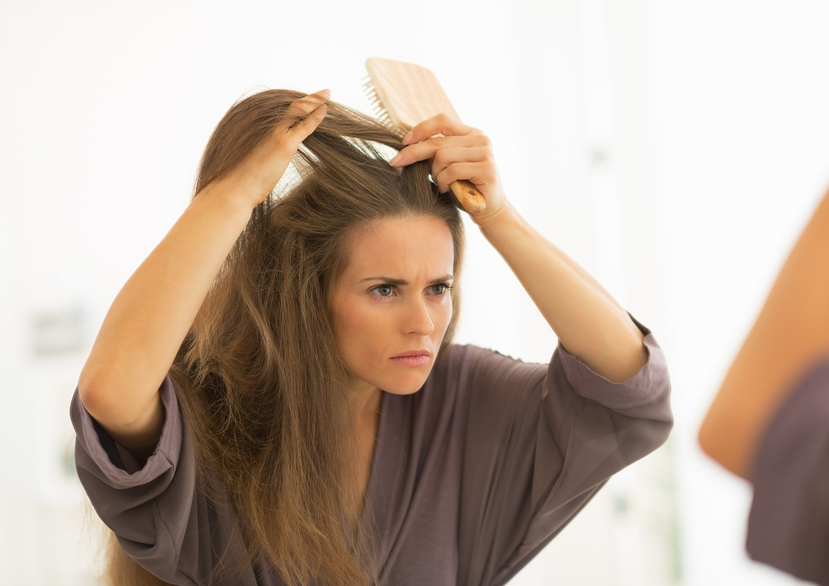 WEB-Concerned-young-woman-combing-hair-bathroom-shutterstock_188544656-Alliance-AI