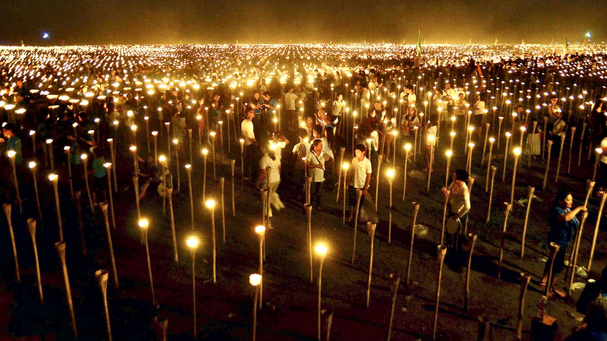 Volunteers light candles during the “Light of Peace in the Phili