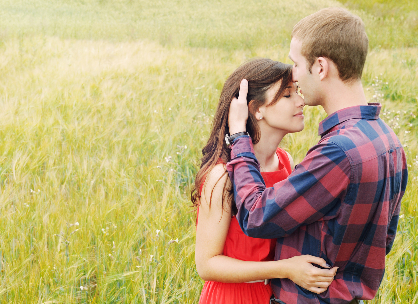 Stunning sensual outdoor portrait of young stylish fashion attractive couple in love kissing in summer field