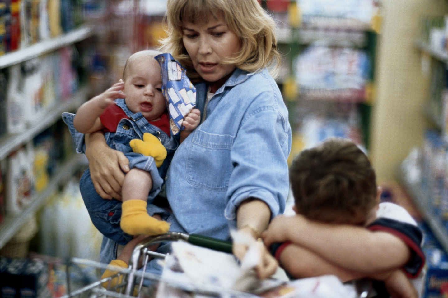 Mother and two children (1-6) shopping in supermarket