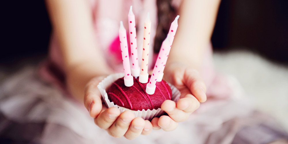 WEB3-CUPCAKE-BIRTHDAY PARTY-CANDLES-HANDS-CHILD-shutterstock_86265694-Alinute Silzeviciute-AI