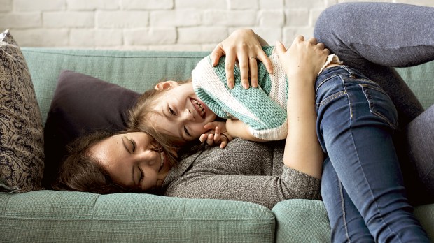 WEB3 MOM CHILD COUCH HUG LAUGH Shutterstock