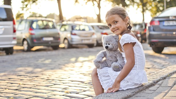 WEB3-GIRL-BEAR-PARKING-LOT-CARS-SMILE-CHILD-Shutterstock
