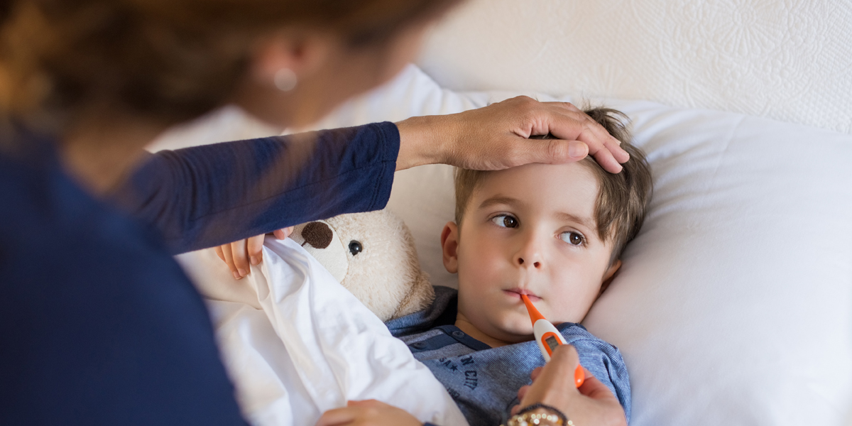 WEB3 MOM AND SON SICK FEVER THERMOMETER CAREGIVER Shutterstock