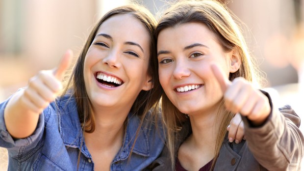 WEB3 FRIENDS WOMEN SMILE SMILING THUMBS UP OUTDOORS FRIENDSHIP Shutterstock