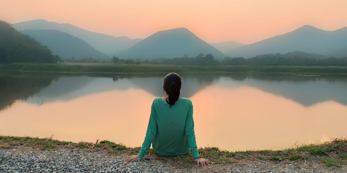 WEB3 WOMAN ALONE SOLITUDE MOUNTAINS LAKE SUNSET SILENCE Shutterstock