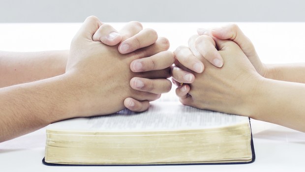 COUPLE QUI PRIE AU DESSUS D'UNE BIBLE
