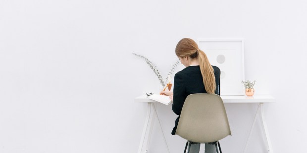 JEUNE FEMME DEVANT UN BUREAU