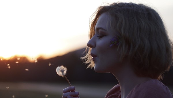 JEUNE FEMME AVEC UN PISSENLIT