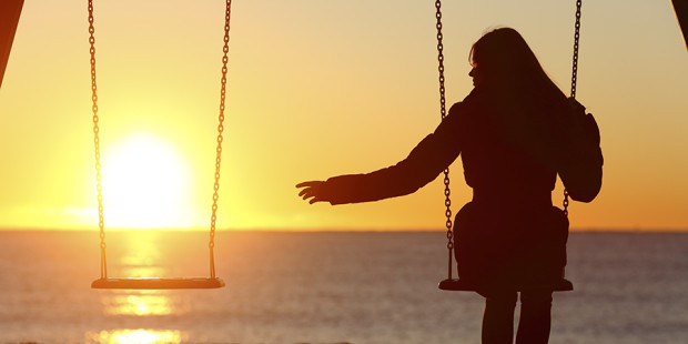 single-woman-swinging-beach-sunset