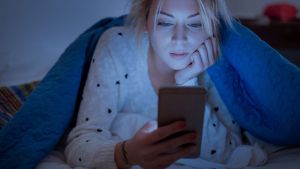 woman-waching-her-cell-phone-at-night