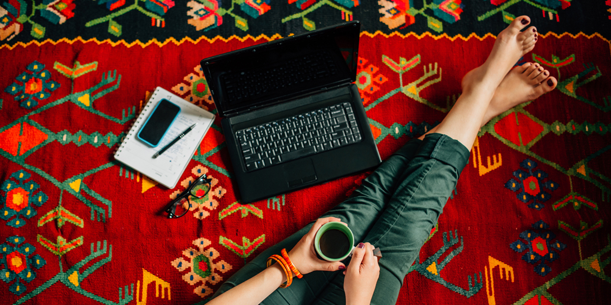 Nogi dziewczyny leżącej na dywanie z laptopem