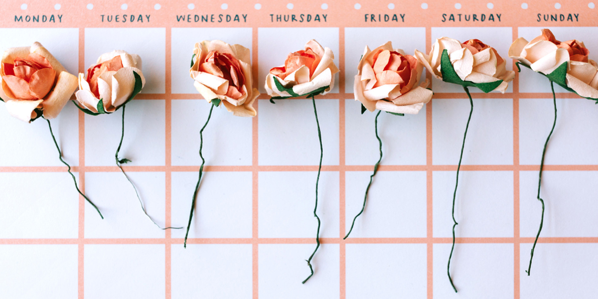 Sztuczne róże leżące na kalendarzu
