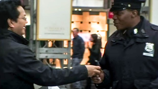 MAN HANDING A POLICE OFFICER A CANDLE