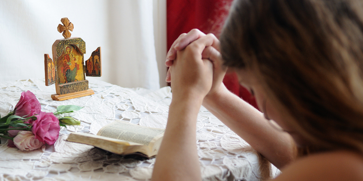 Young girl praying at home
