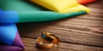 WEDDING RINGS AND RAINBOW GAY FLAG