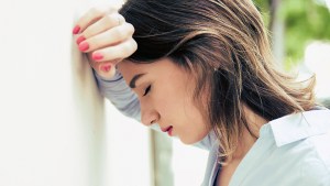 WOMAN LEANING ON WALL