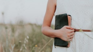 WOMAN,HOLDING,BIBLE,FIELD