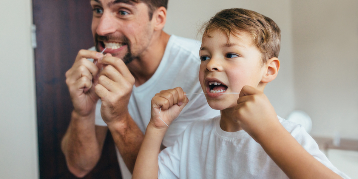 little boy with his father cleaning teeth