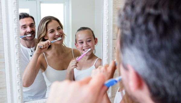 Parents and daughter brushing their teeth
