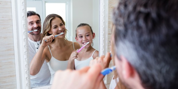 Parents and daughter brushing their teeth