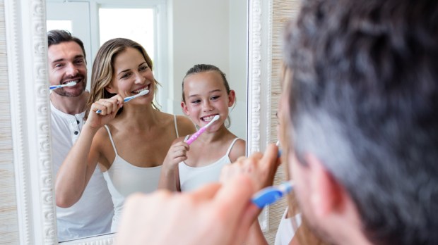 Parents and daughter brushing their teeth
