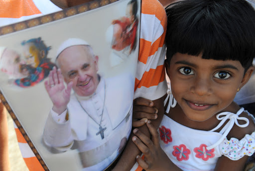 A young Sri Lankan holds paraphernalia bearing the portrait of Pope Francis – ar