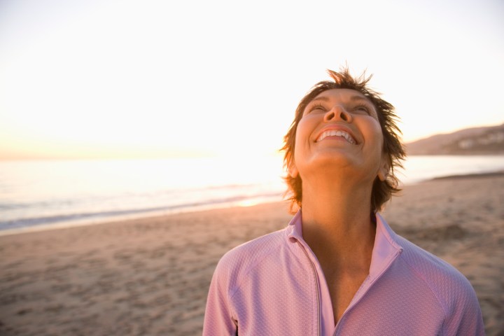 Mature woman at beach looking at sky