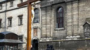 Mężczyzna obejmuje krzyż przed kościołem we Lwowie