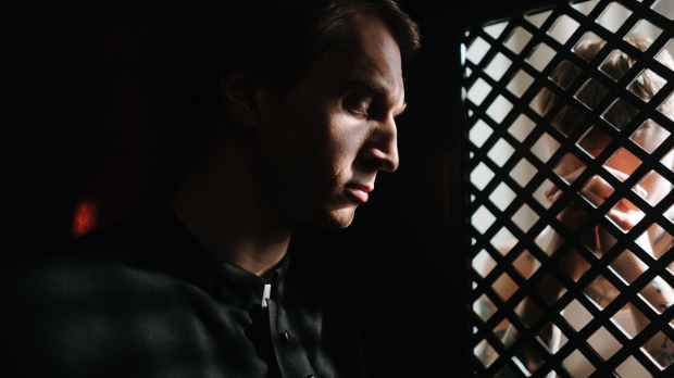 a priest listening to the person confessing