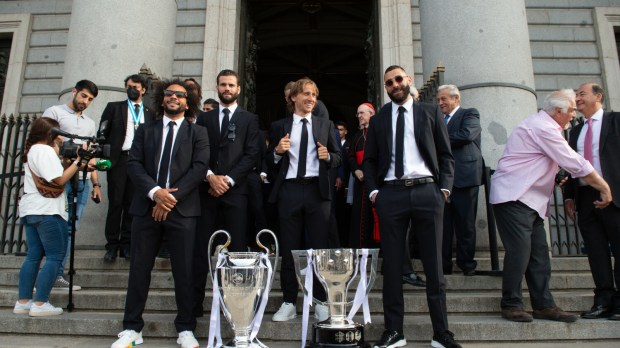 Piłkarze Realu Madryt z trofeum za zwycięstwo w Lidze Mistrzów stoją przed katedrą La Almudena w Madrycie