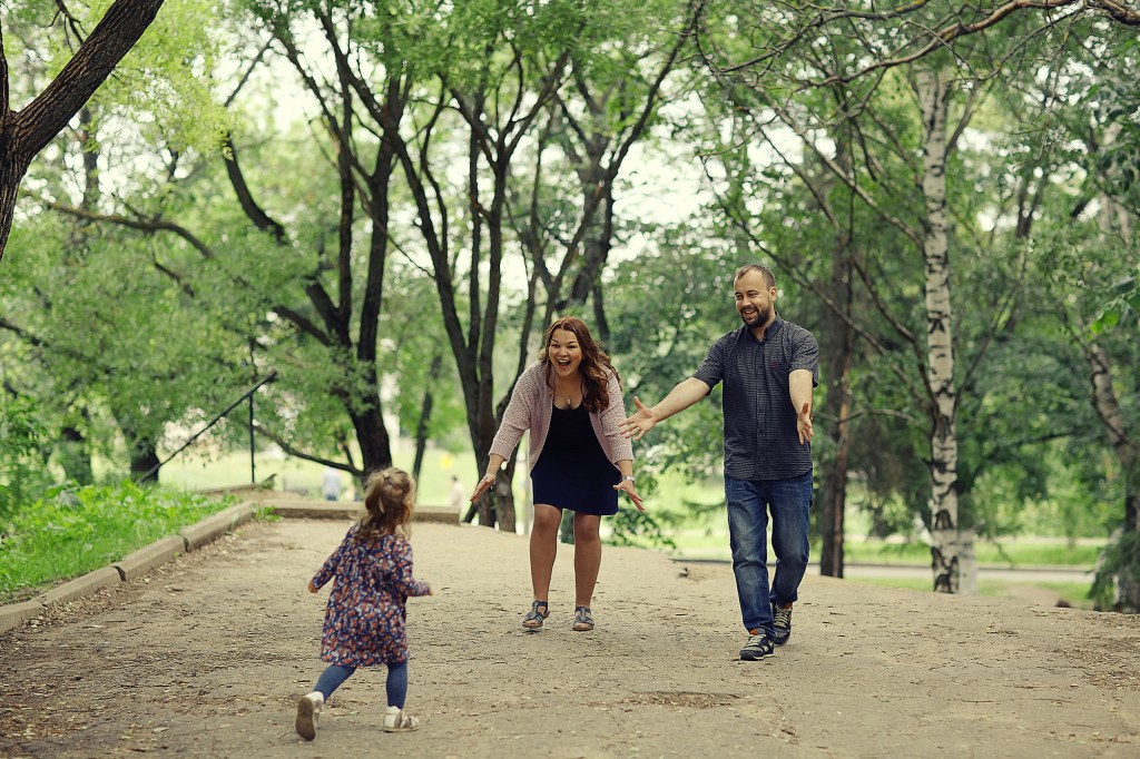 Mom-and-young-daughter-and-dad-a-young-family-on-a-walk-in-the-park-in-summer