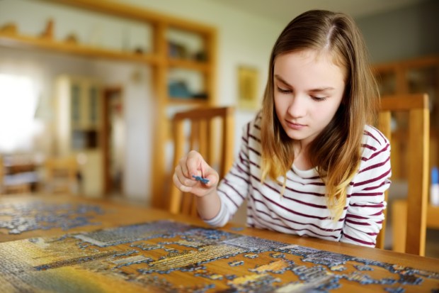 dziewczyna ćwiczy cierpliwość, układając puzzle