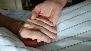 HOLDING HANDS WITH DYING PATIENT