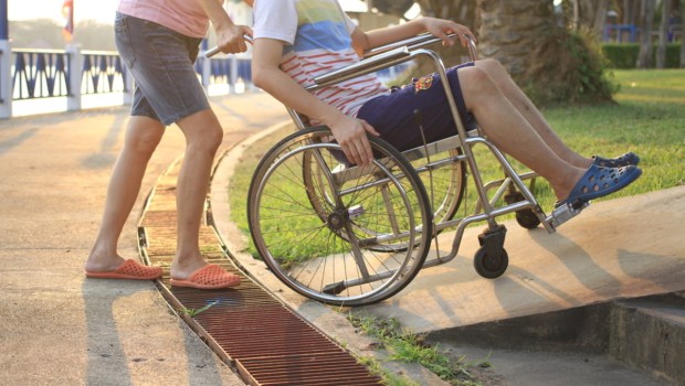 Mother helping her son on wheelchair