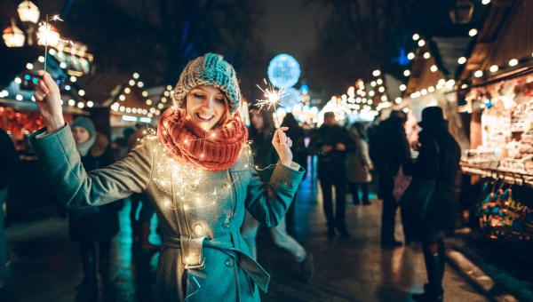 young woman with sparklers and Christmas lights