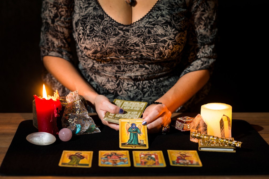 womans-hands-placing-tarot-cards-shutterstock