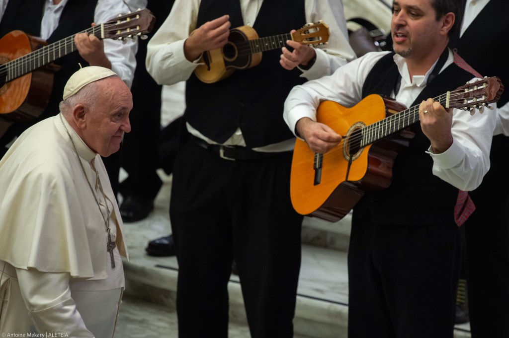 Pope Francis passes by musicians