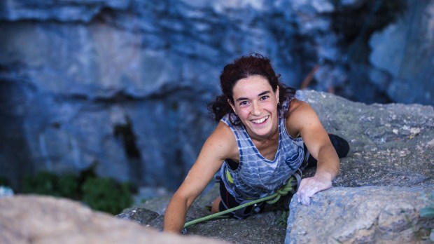 smiling young woman rock climbing