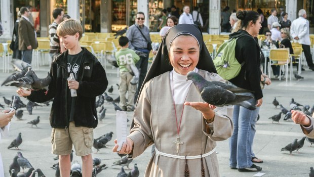 Monja sonriente con una paloma en mano