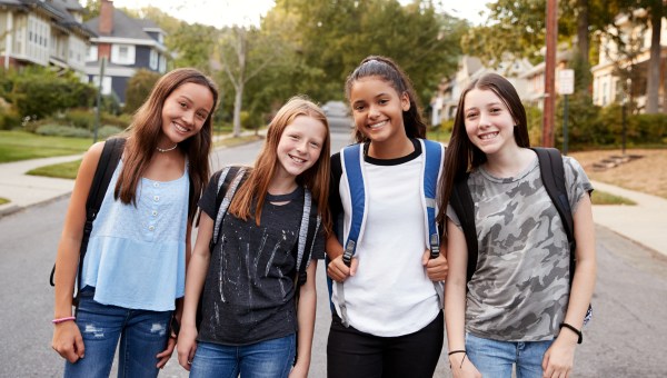 Teen girls on the way to school looking to camera, close up