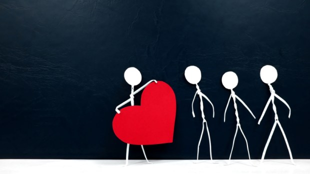 Human stick figure holding a big red heart in dark background