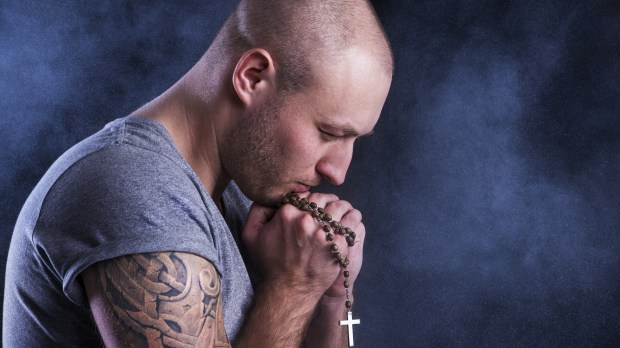 Man with tattoo and rosary