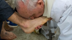 Pope Francis kissing the feet of a young offender after washing them during a mass at the church of the Casal del Marmo youth prison