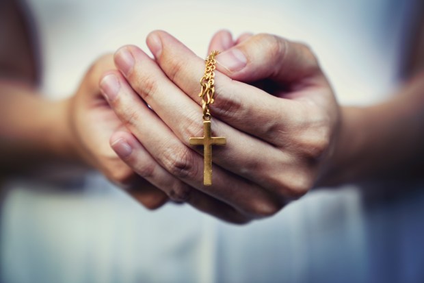 Różaniec trzymany w kobiecych dłoniach