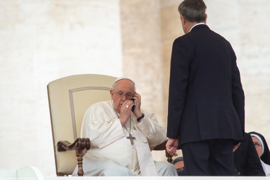 Pope Francis speaks on phone during hi weekly general audience