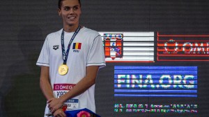 Romania's David Popovici celebrates in the podium of the Men's 100m Freestyle at the 8th FINA World Junior Swimming Championship in Lima