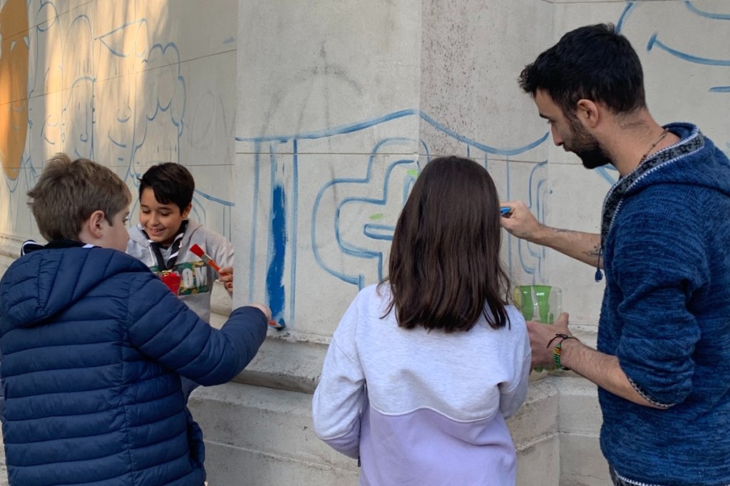 Cristian Camargo (crisdibujante) realizando un mural comunitario en compañía de los niños para celebrar el décimo aniversario del pontificado del Papa Francisco